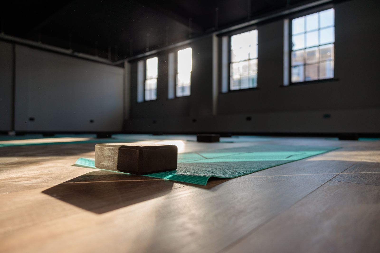 Studio 1 with natural light and yoga mats laid out on the floor